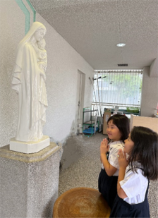 マリアさまの御像に向かって手を合わせる子どもたちの写真